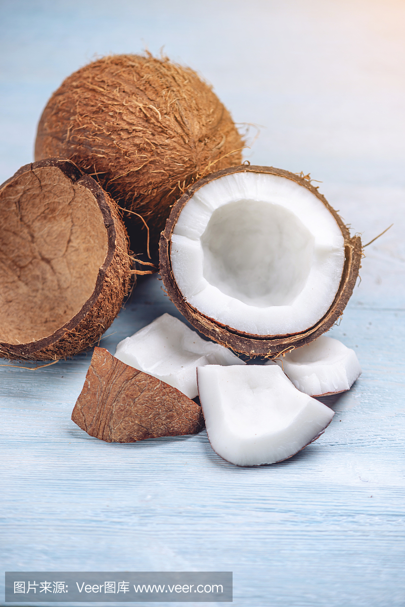 打開(kāi)椰子與白色果肉在藍(lán)色木制背景。有機(jī)健康膳食產(chǎn)品廣泛應(yīng)用于化妝品